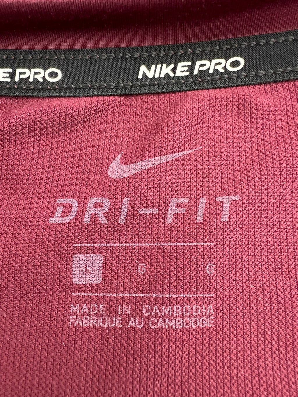 Close-up of Nike Pro Dri-FIT label inside the burgundy top