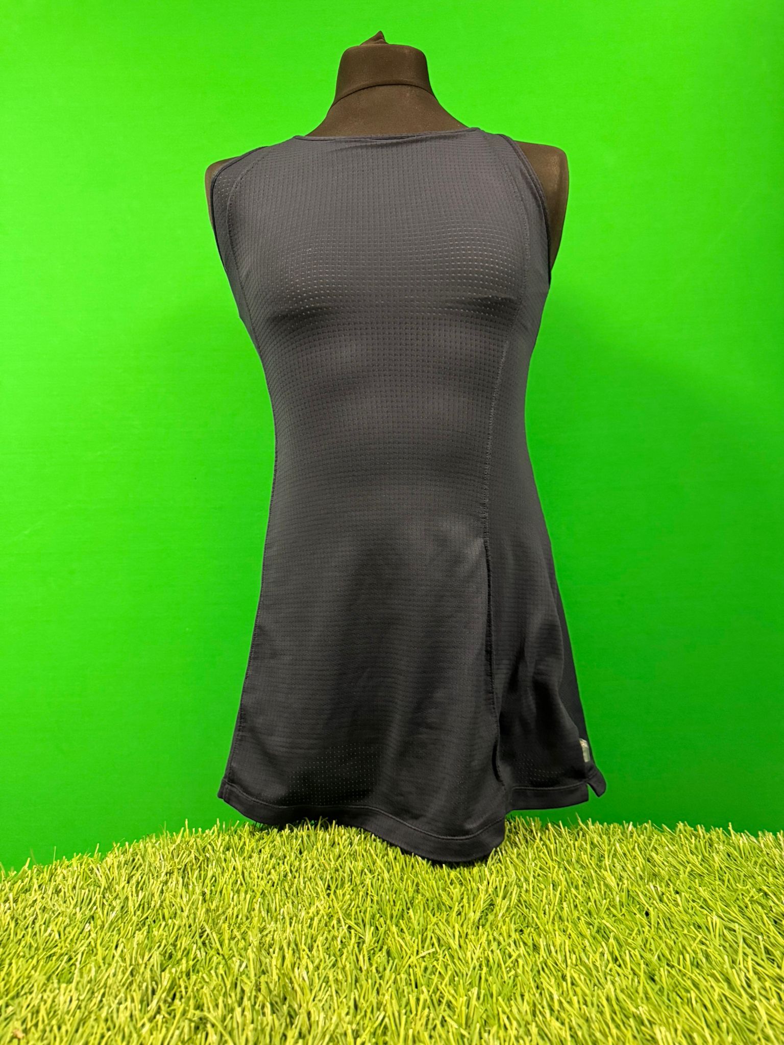 Front view of a dark blue Nike women's tennis dress on mannequin with sleeveless design and subtle textured fabric