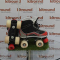 Pair of black, red, and white kids' quad roller boots on display