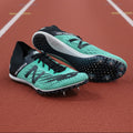 Pair of New Balance mint green spike running shoes on artificial grass, one shoe showing outsole with visible spikes