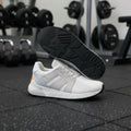 Pair of white mesh running trainers with rubber sole and suede details shown from side and bottom