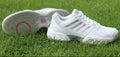 Side and bottom view of K-Swiss white and pink trainers on grass