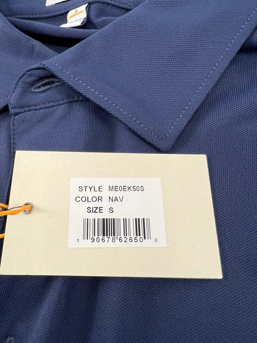 Close-up of Peter Millar polo shirt tag showing style number, color, and size S