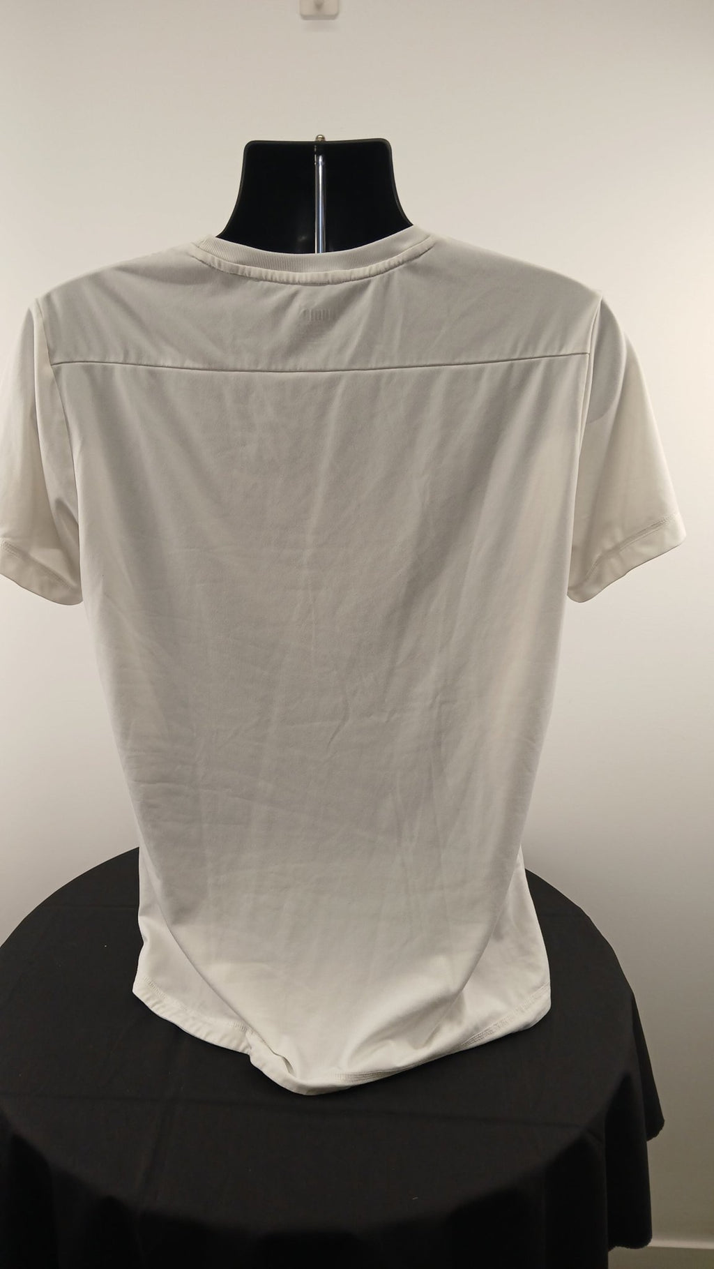Back view of Puma white sports t-shirt displayed on a mannequin