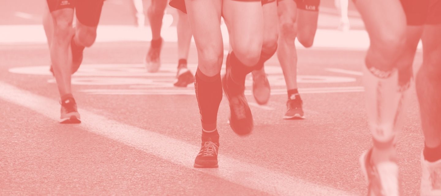 Red-tinted image of runners' legs in a race