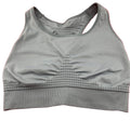 Front view of grey Sweaty Betty seamless sports bra on red background