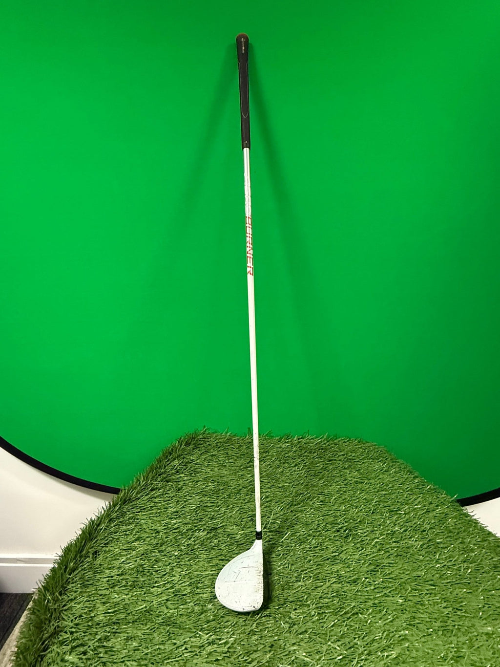 TaylorMade AeroBurner 14° fairway wood golf club standing on artificial grass against a green background