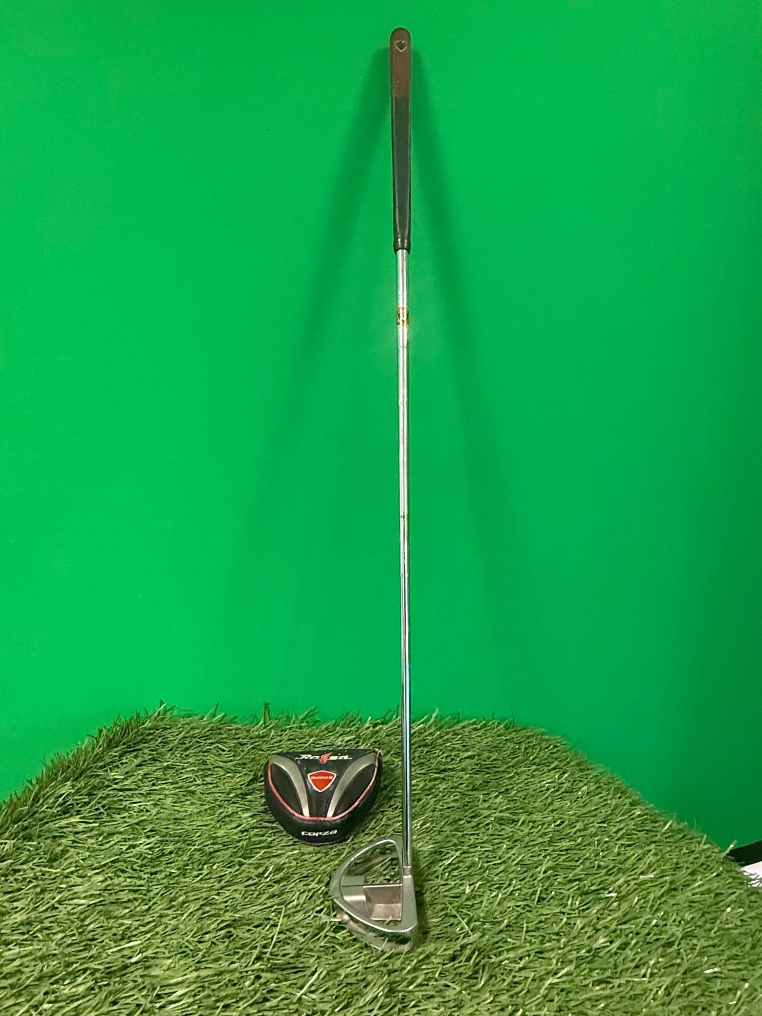 Taylormade Rossa Putter with headcover on artificial grass with green background