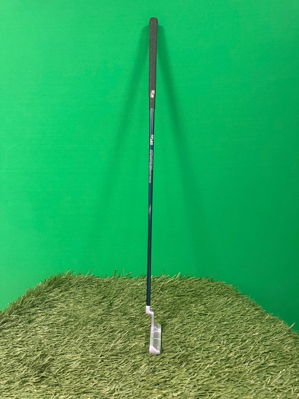 Texan Classics JR Tour left-handed putter standing upright on artificial grass with green background