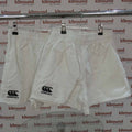 Two pairs of white Canterbury rugby shorts with logos on front