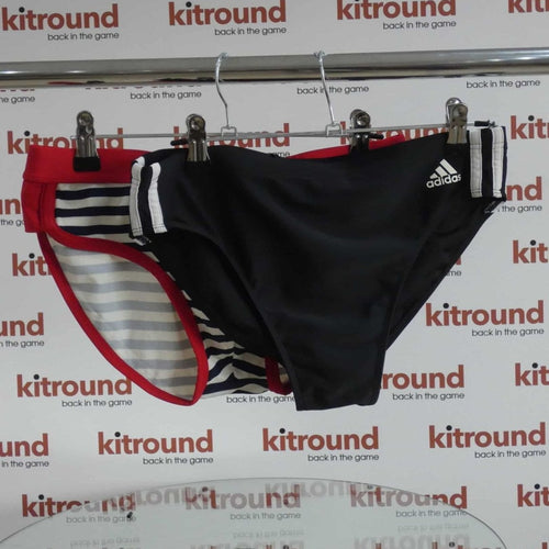 Two pairs of swimming trunks hung on a rail with kitround branding in background