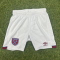 Front view of Umbro West Ham United white youth football shorts on grass