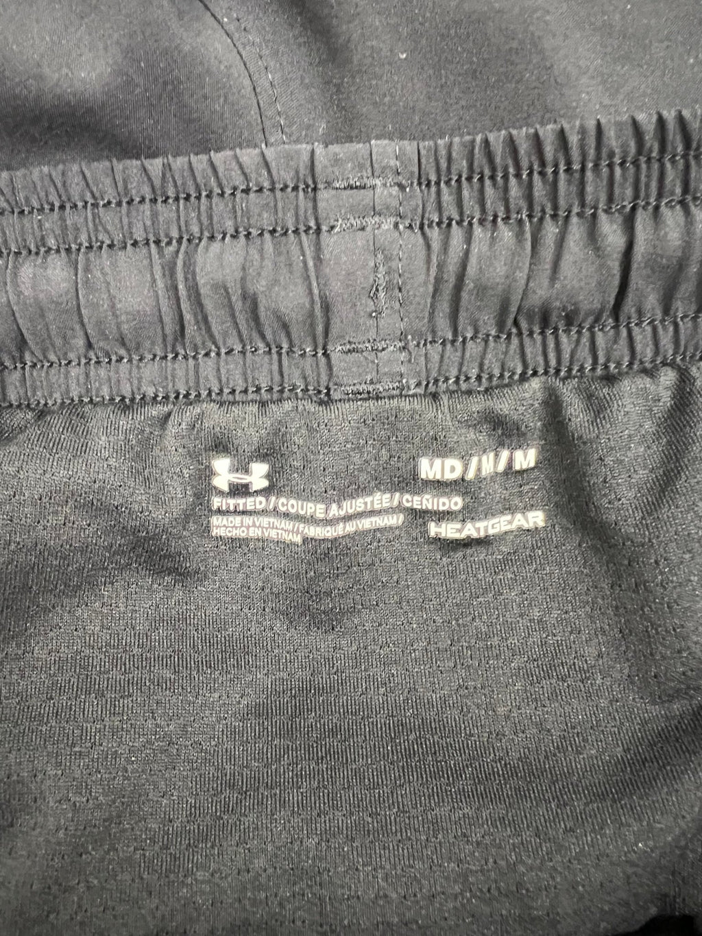 Close-up of Under Armour HeatGear fitted waistband label inside the shorts