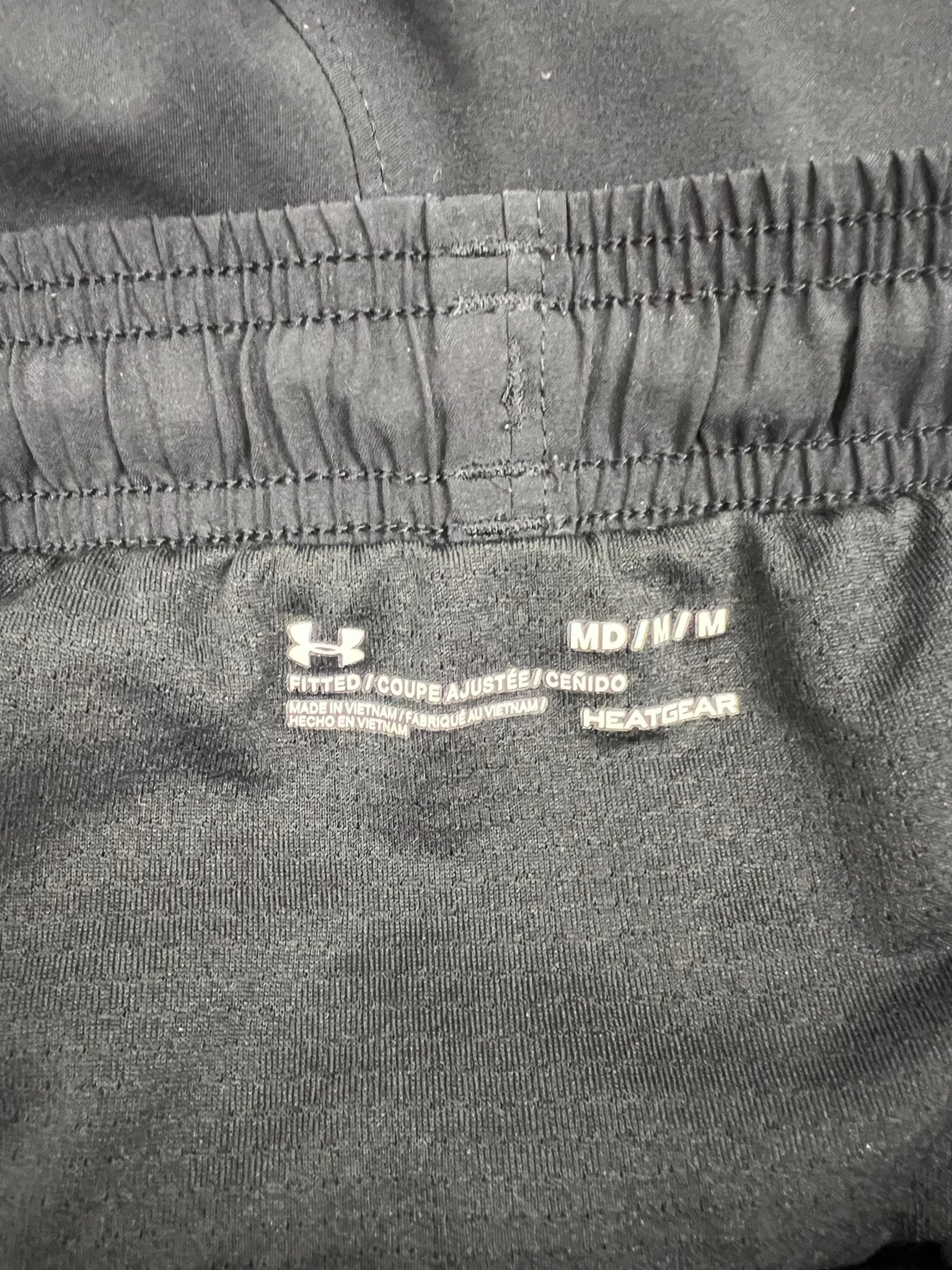 Close-up of Under Armour HeatGear fitted waistband label inside the shorts