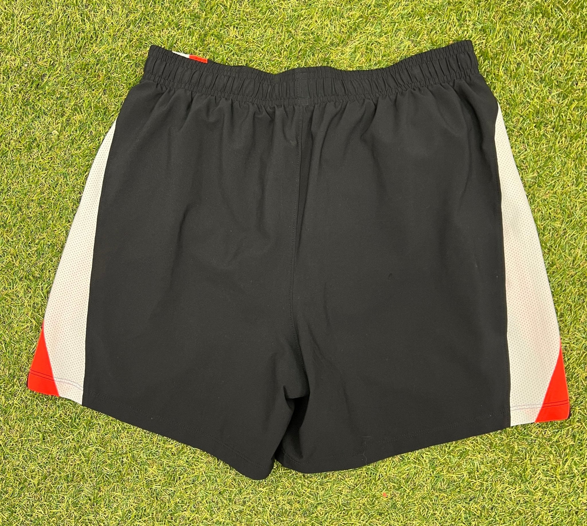 Back view of black Under Armour running shorts with mesh side panels