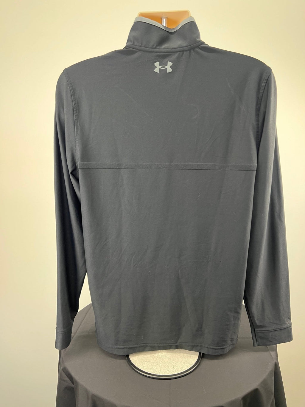 Back view of Under Armour black 1/4 zip golf top with logo detail
