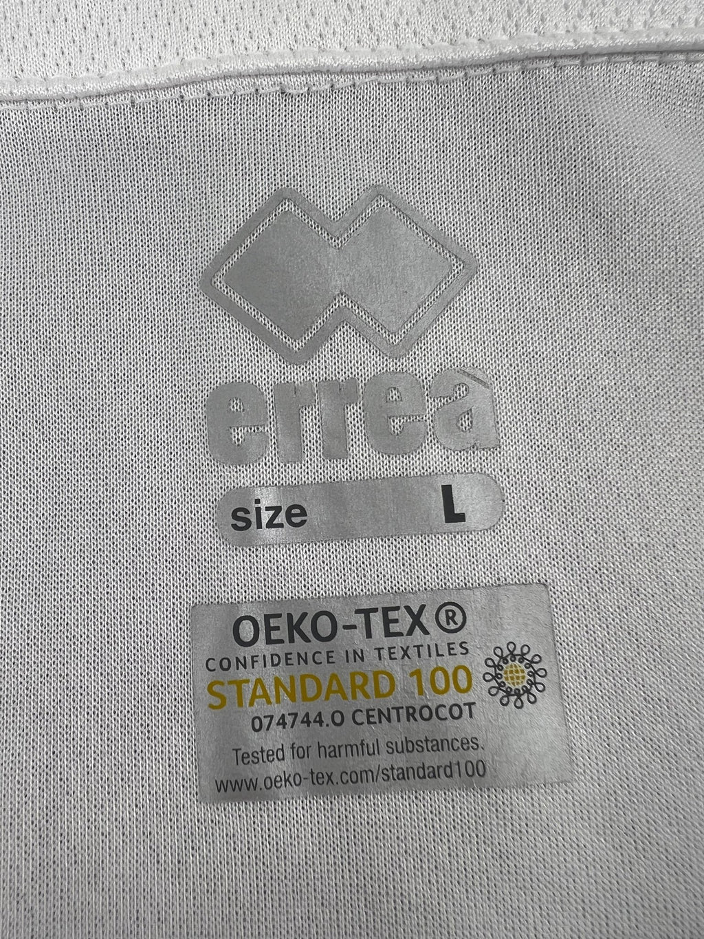 Close-up of Errea logo and OEKO-TEX Standard 100 certification label inside shirt