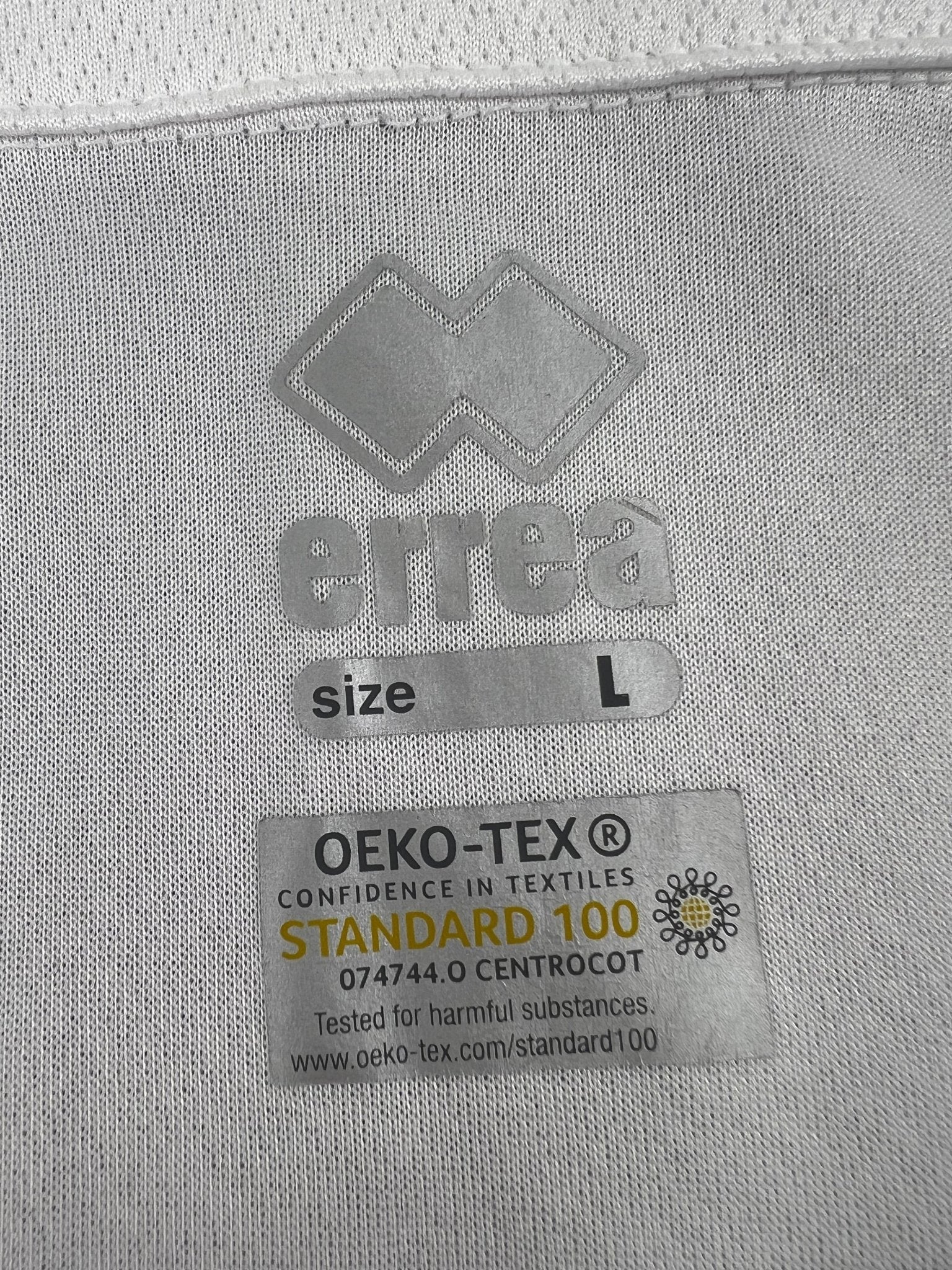 Close-up of Errea logo and OEKO-TEX Standard 100 certification label inside shirt