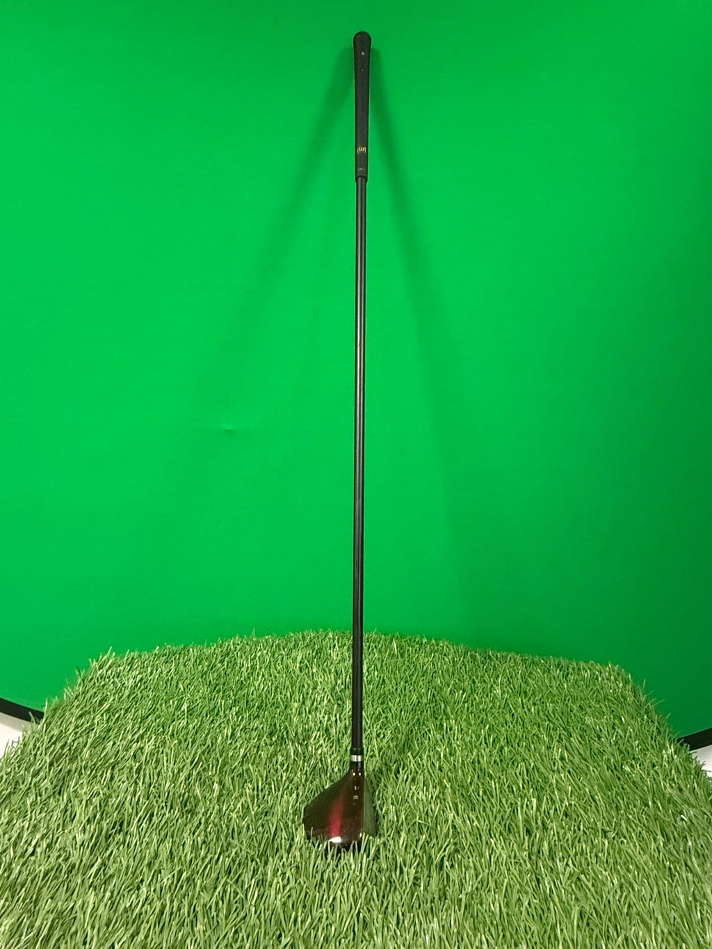 Wilson Deep Red Fat Shaft 7 wood golf club standing upright on artificial grass
