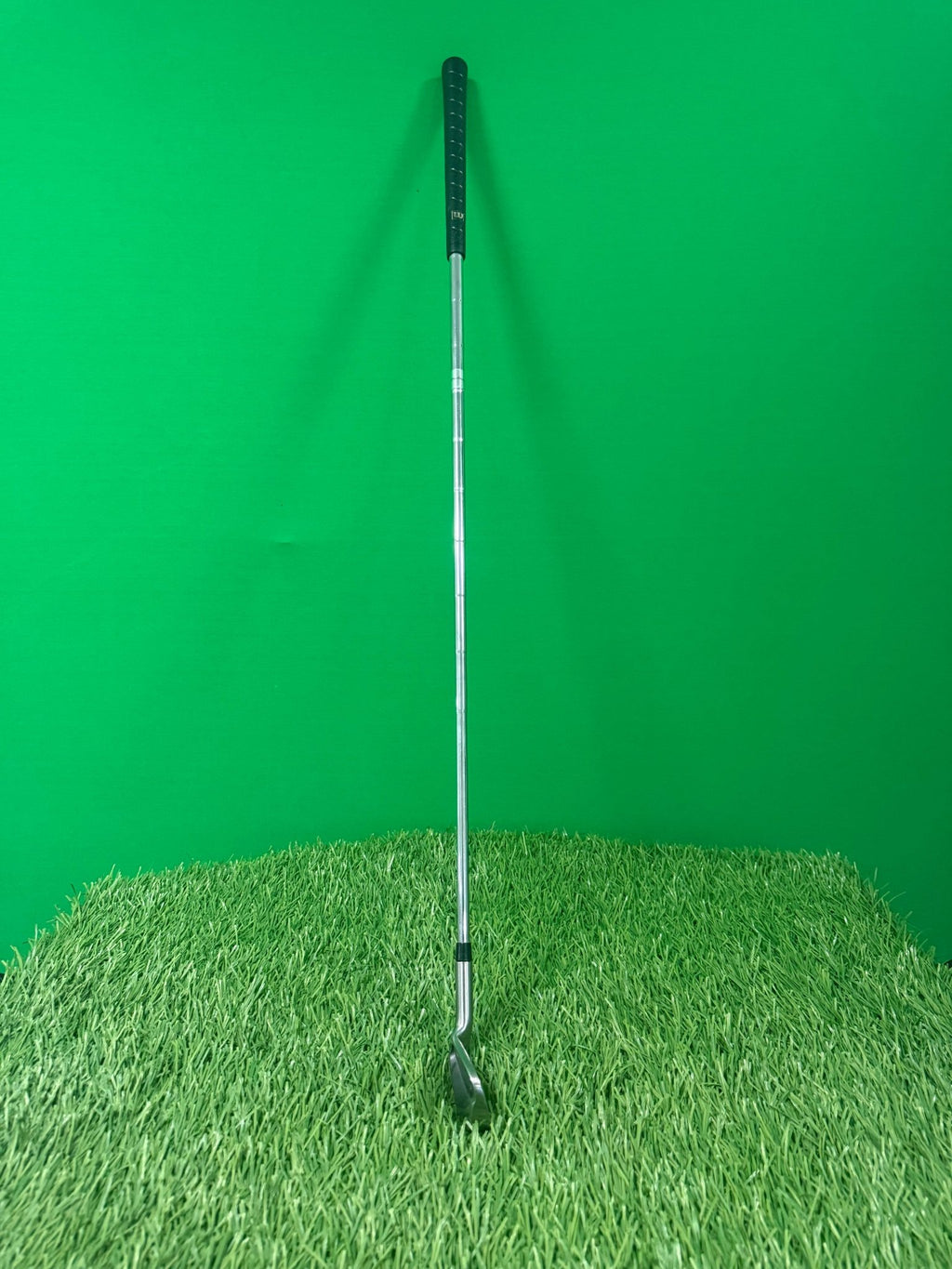 Wilson Prostaff ODPlus 3 iron standing upright on artificial grass with a green background
