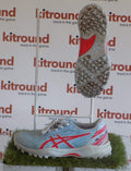 Side and sole view of Asics Astro Trainers in blue with red detailing, displayed on artificial grass