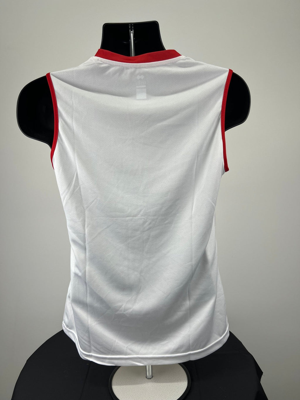 Back view of plain white women's volleyball vest with red trim on armholes and neck