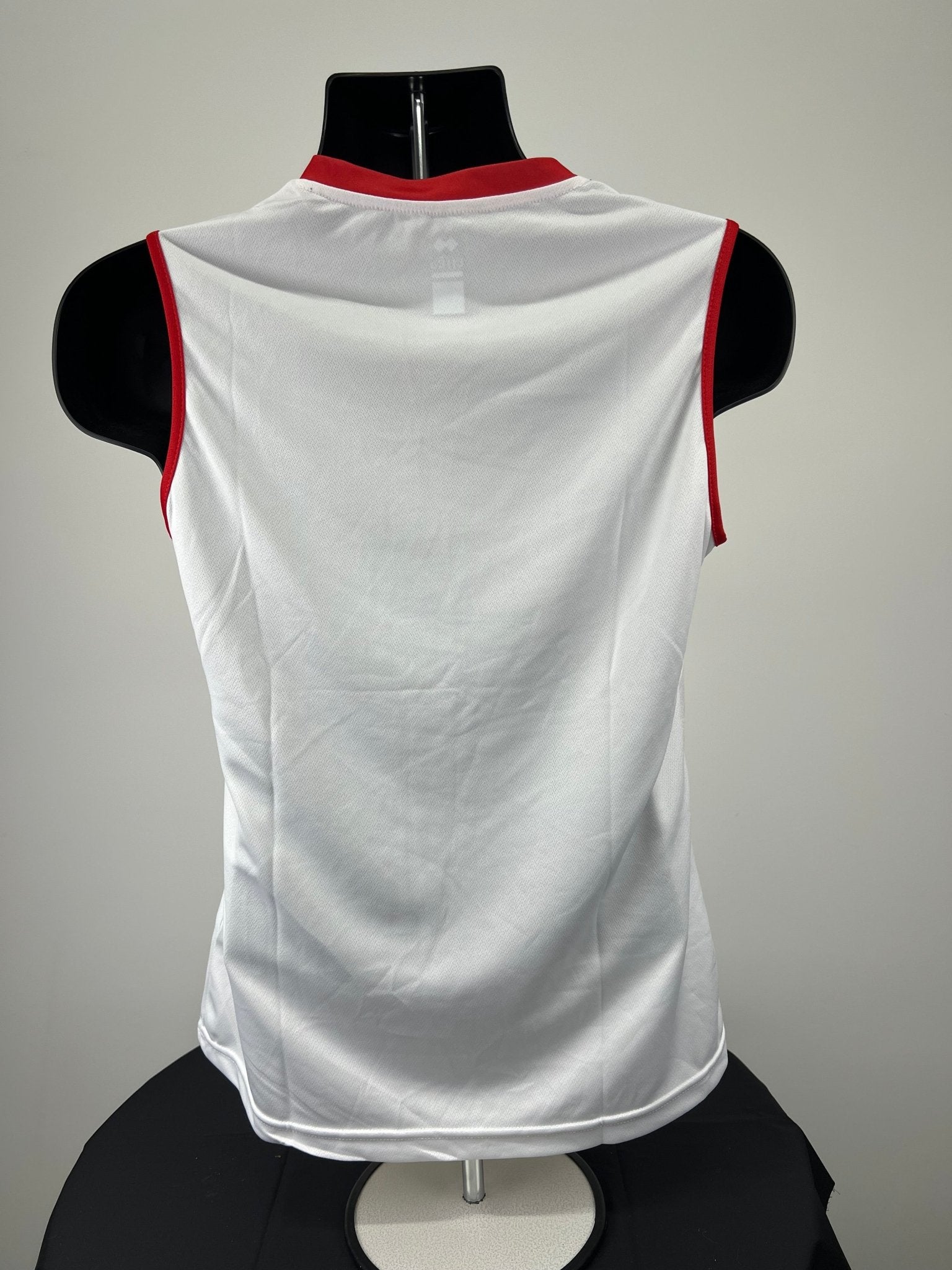Back view of plain white women's volleyball vest with red trim on armholes and neck