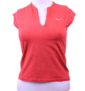 Front view of coral Nike women's sports top with notched neckline and short sleeves