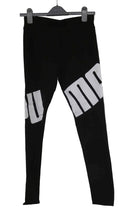 Black Puma sports leggings with large white logo across the legs