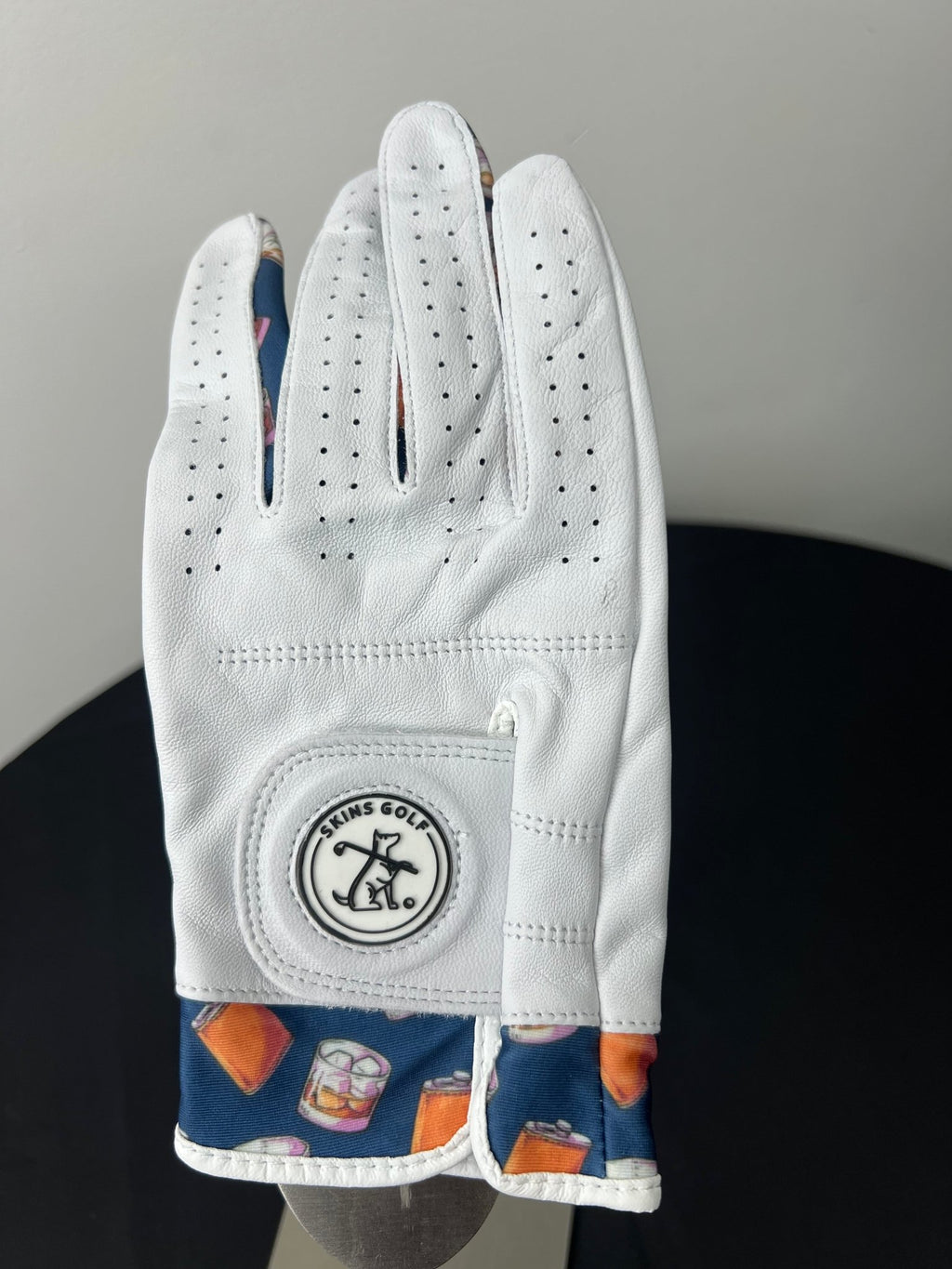 Women's right hand golf glove with whiskey motif trim, front view
