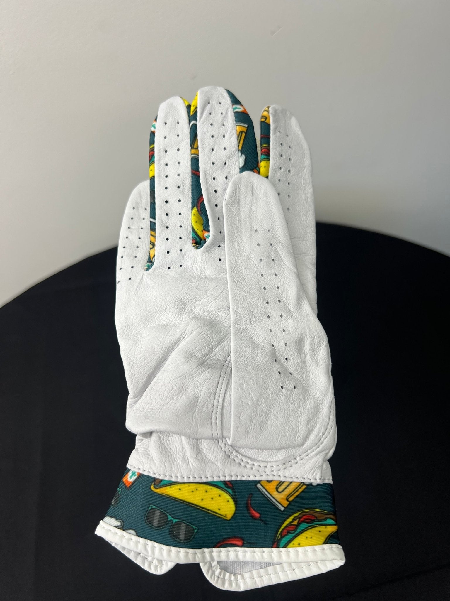 Back view of white golf glove with colorful taco and beer motif details