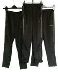 Three pairs of black athletic trousers with side stripes on hangers