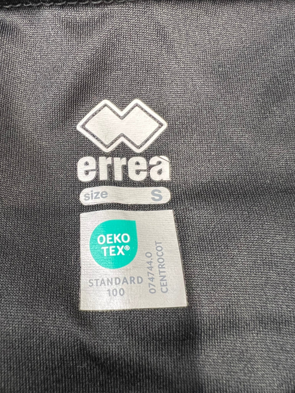 Close-up of Errea and Oeko-Tex label inside the polo shirt