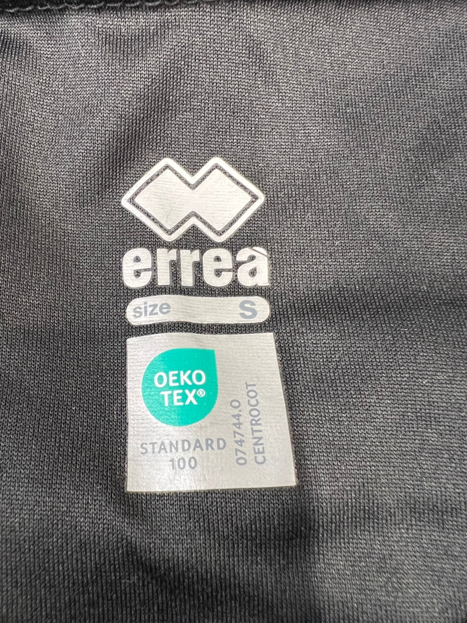 Close-up of Errea and Oeko-Tex label inside the polo shirt