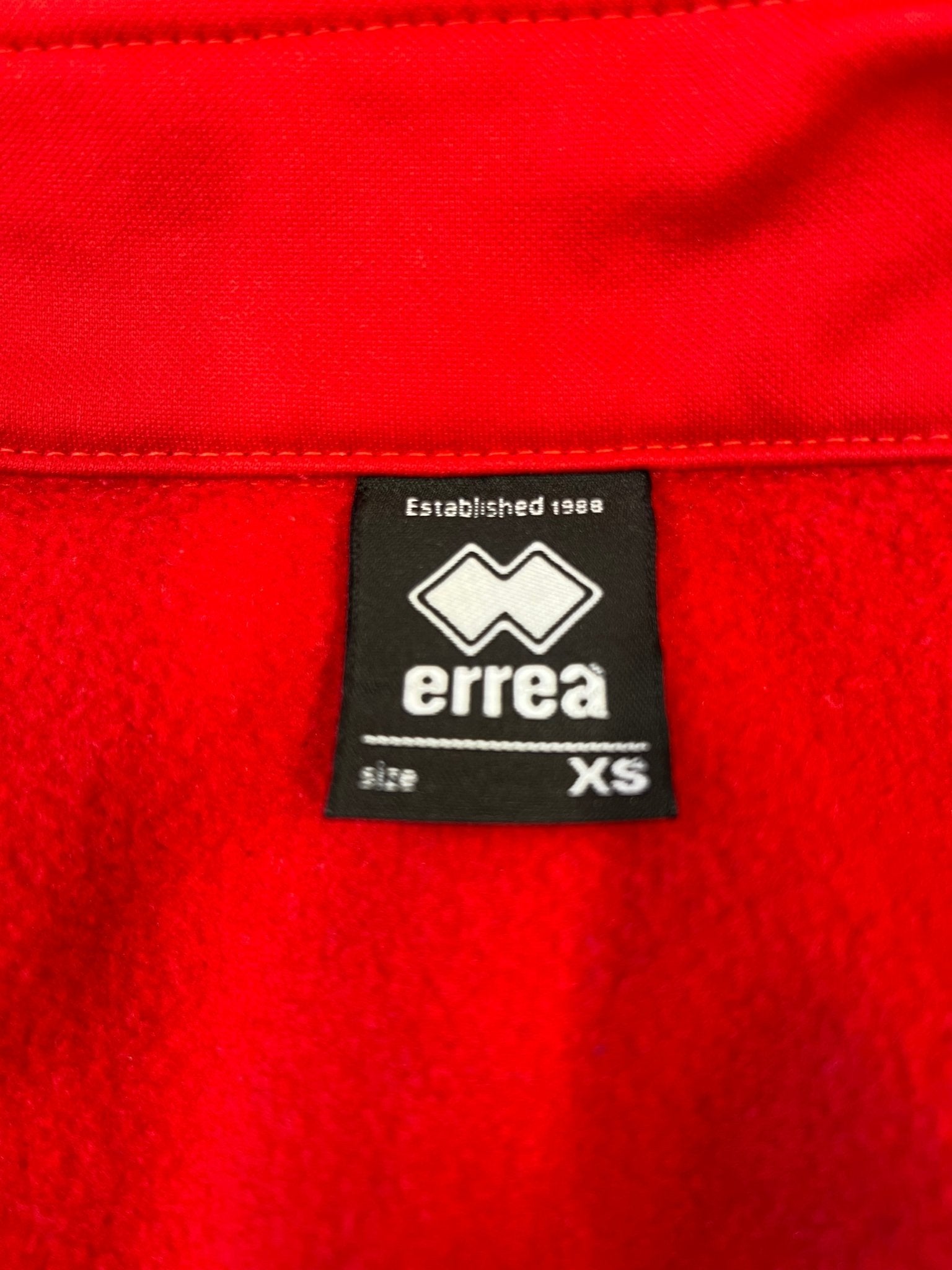 Close-up of Errea brand label inside the collar indicating size XS