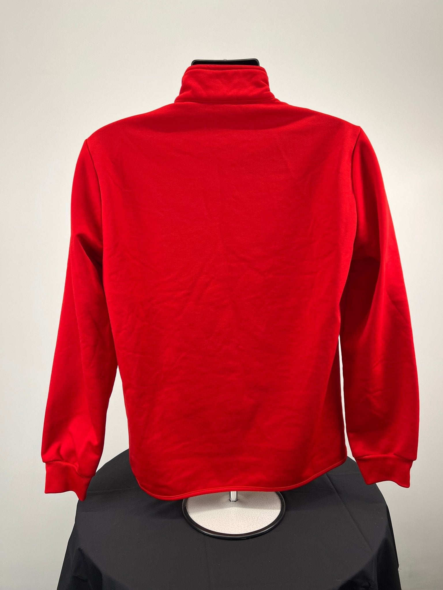 Back view of plain red full zip jacket showing smooth material and ribbed cuffs