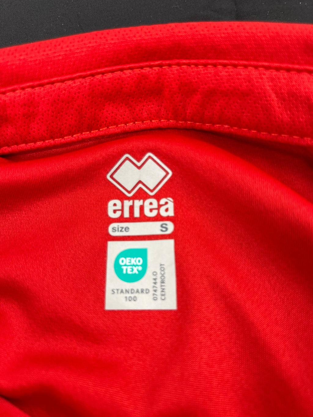 Close-up of Erreà label and Oeko-Tex certification inside the collar