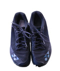 Pair of black Yonex Aerus gym trainers, top view on grass