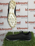 Kipsta youth black football boot side and sole view on artificial grass display