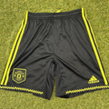 Front of Adidas Manchester United youth black shorts with yellow stripes and logos